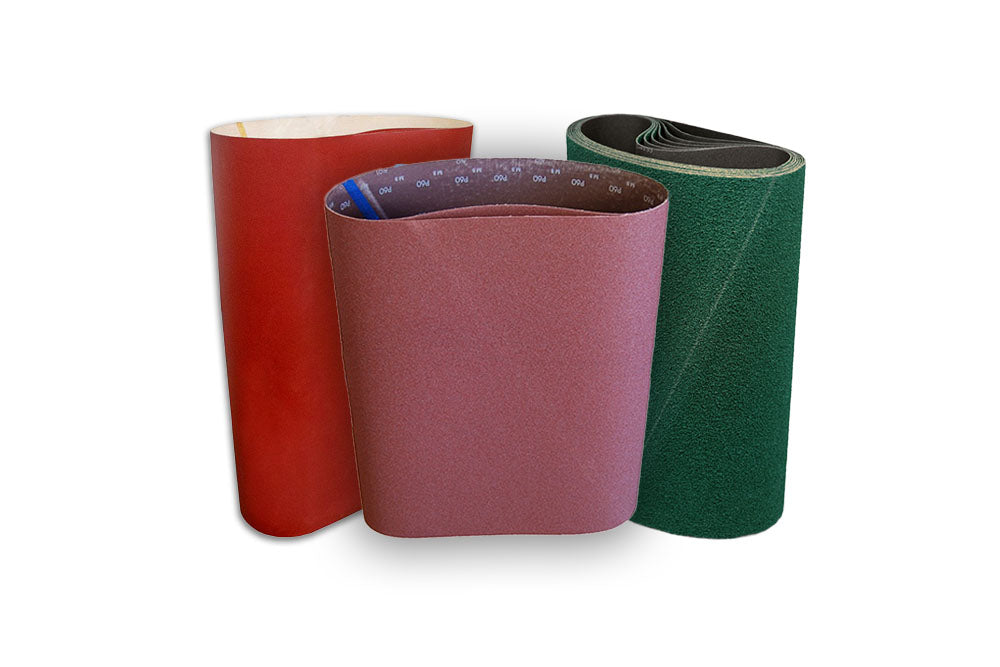 Three rolls of red, purple and green sanding belt material