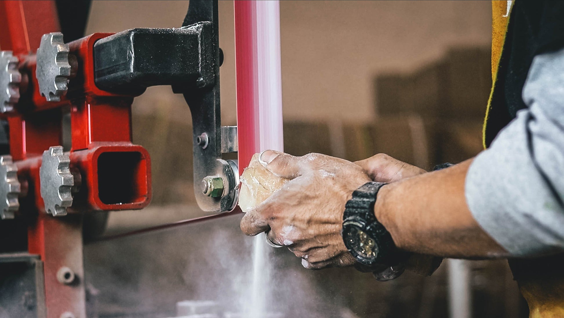 Man using a belt eraser to clean a sanding belt, effectively removing debris and extending belt life.